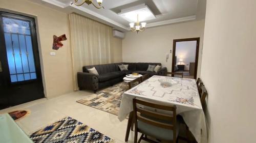 a living room with a table and a couch at Amzing two bedrooms in the middle of amman in Amman