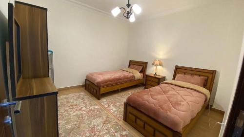 a bedroom with two beds and a lamp in it at Amzing two bedrooms in the middle of amman in Amman