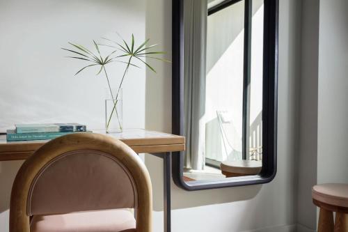 a chair sitting next to a table with a mirror at Hotel Indigo Grand Cayman by IHG in Grand Cayman