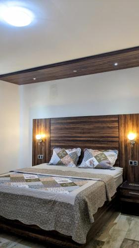 a bedroom with a large bed with a wooden headboard at Toilcam in Buea