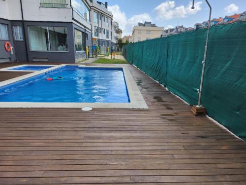 una piscina su una terrazza in legno accanto a una recinzione di Apartamento de playa familiar, piscina y garaje. a Ares