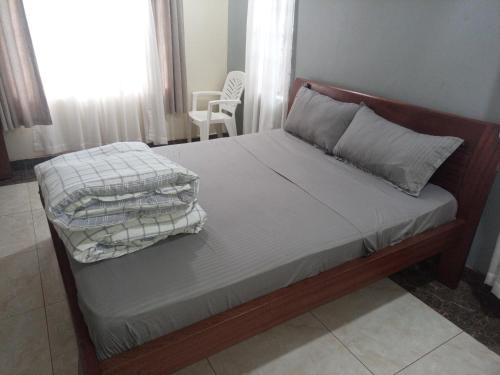 een slaapkamer met een bed met 2 kussens erop bij Serene Modern 3 bedroom house near Mombasa Road in Emali