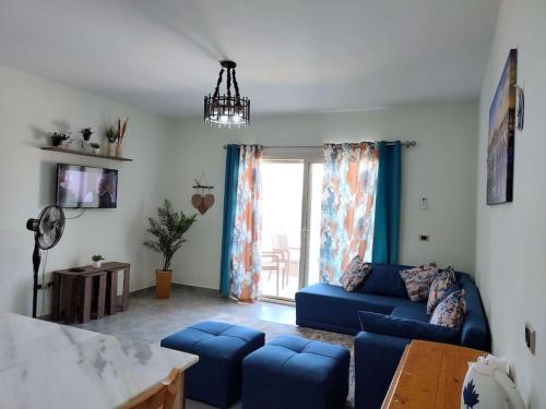 The Groove Ain Sokhna في العين السخنة: غرفة معيشة مع أريكة زرقاء ونافذة