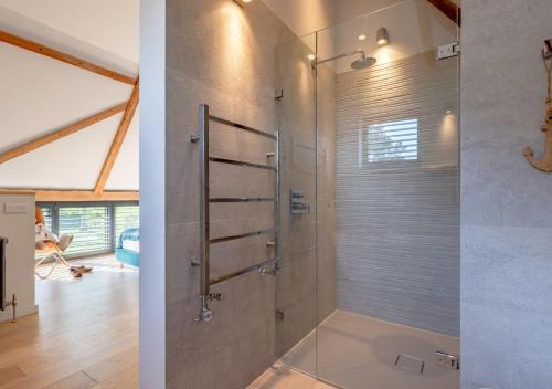 a bathroom with a shower with a glass door at Alexandra Barn in Shadingfield