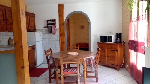 une cuisine avec une table et des chaises dans une cuisine dans l'établissement Villa Soleil 12 rue Joseph Mathieu, à Guillestre