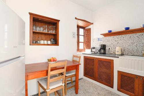 a kitchen with a wooden table and a counter at Villa Nouna in Líndos
