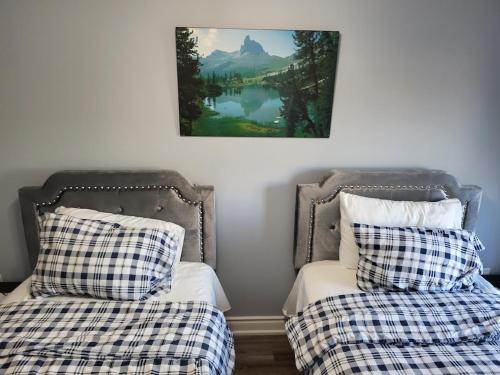 two beds sitting next to each other in a room at Luxury Home in Mississauga in Mississauga