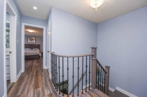 a hallway with a staircase with a bed in a bedroom at Luxury Home in Mississauga in Mississauga