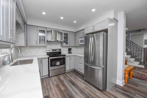 a kitchen with white cabinets and a stainless steel refrigerator at 4 bedrooms 4 baths complete Home in Churchill Meadows, Mississauga in Mississauga