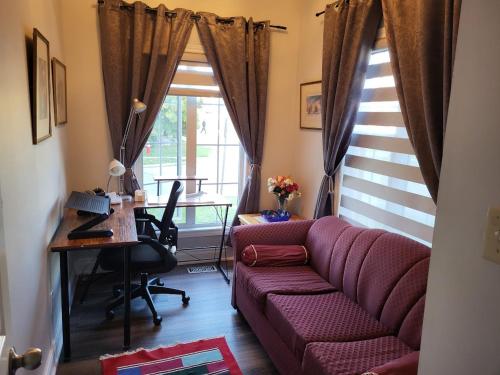 a living room with a purple couch and a desk at Luxury Home in Mississauga in Mississauga