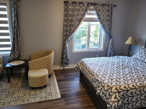 a bedroom with a bed and a chair and a window at Luxury Home in Mississauga in Mississauga