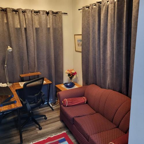 a living room with a couch and a desk and a chair at Luxury Home in Mississauga in Mississauga