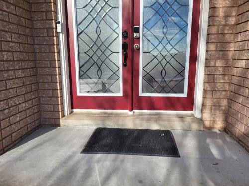 a red door with a black mat in front of it at Luxury Home in Mississauga in Mississauga