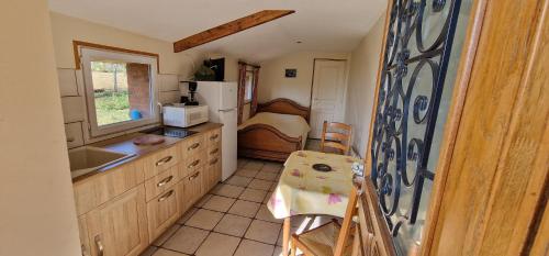a small kitchen with a sink and a bedroom at AU Bosquet fleuri in Cosges