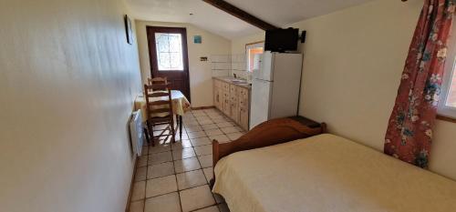 a small room with a bed and a kitchen at AU Bosquet fleuri in Cosges
