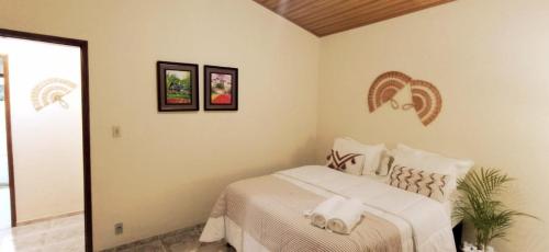 Schlafzimmer mit einem Bett mit weißer Bettwäsche in der Unterkunft Recanto das Neves in Miguel Pereira