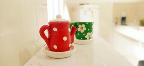 a red tea pot sitting in a bowl on a counter at Recanto das Neves in Miguel Pereira