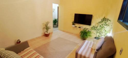 a living room with a couch and a flat screen tv at Recanto das Neves in Miguel Pereira
