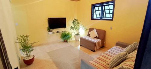 ein Wohnzimmer mit einem Sofa und einem TV in der Unterkunft Recanto das Neves in Miguel Pereira