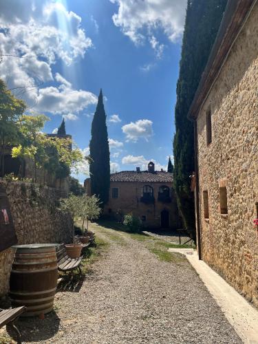 an alley in an italian village with trees and buildings at Castel Pietraio WineResort in Monteriggioni