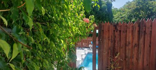 a fence next to a swimming pool next to a wooden fence at Apartment Joanna in Rodney Bay Village