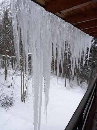 a bunch of icicles hanging from a roof in the snow at Le Marmotte - Appartamento in Abetone