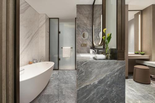 a bathroom with a tub and a sink at InterContinental Hotels Zhengzhou in Zhengzhou