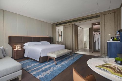a bedroom with a bed and a table and a couch at InterContinental Hotels Zhengzhou in Zhengzhou
