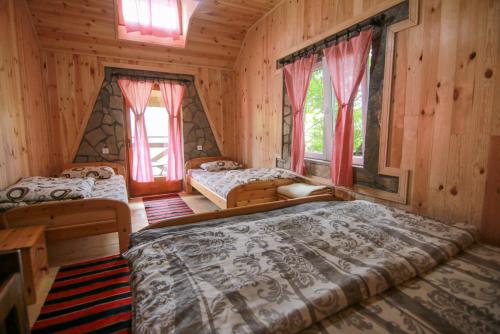 1 dormitorio con 2 camas en una cabaña de madera en Country Villa MMMM, en Mojkovac