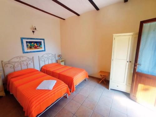 two beds in a room with orange sheets at Don Federico Country Inn in Moscufo