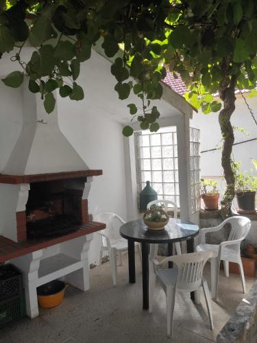 a patio with a table and chairs and a fireplace at Casa Na Montanha Da Neve in Seia