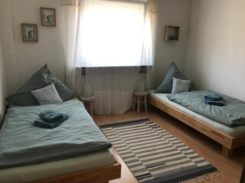 two beds in a room with a window at Auszeit im Pott - Ferienwohnung Minze in Herten