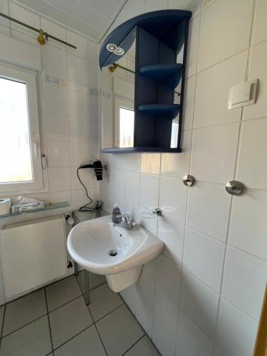 Baño blanco con lavabo y espejo en Auszeit im Pott - Ferienwohnung Minze en Herten