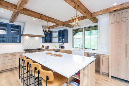 una cocina con armarios de madera y una gran isla blanca en Overlook House home en Telluride