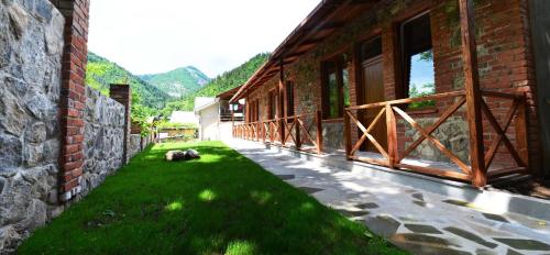 a dog laying on the grass next to a building at Borjomi Cottages in Borjomi