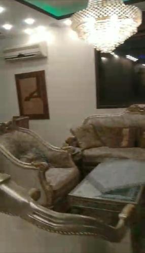 ein Wohnzimmer mit 2 Sofas und einem Kronleuchter in der Unterkunft شاليه الهيبة alhaybeh chalet in Amman