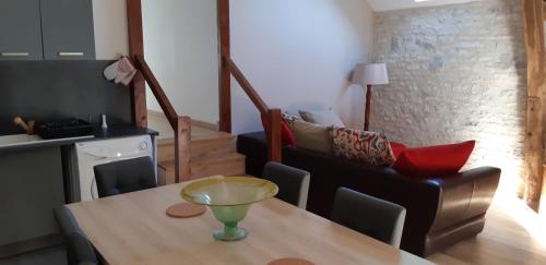 a dining room with a table and a couch at Le Célé in Orniac
