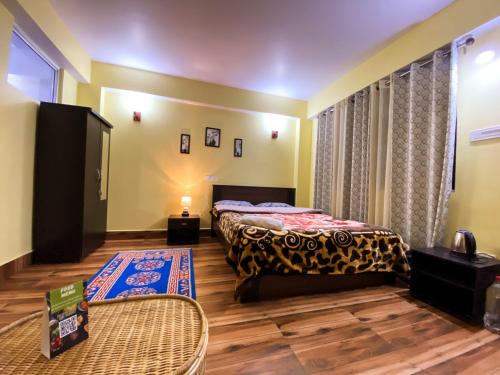 sypialnia z łóżkiem i telewizorem w pokoju w obiekcie Syangden Villa, Nagbeli BNB w mieście Dardżyling