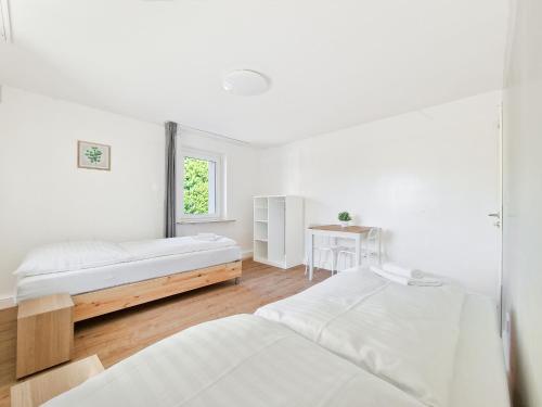 a white room with two beds and a window at RAJ Living - 3 Room Apartments - 20 Min to Messe DUS & Old Town DUS in Meerbusch