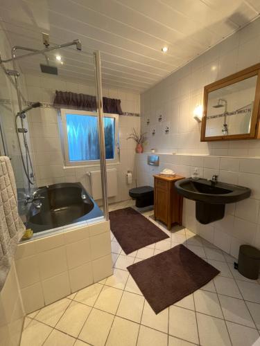 a bathroom with a bath tub and a sink at Auszeit im Pott - Ferienwohnung Lavendel in Herten
