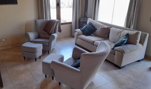salon z kanapą i 2 krzesłami w obiekcie MI CASA w mieście El Calafate