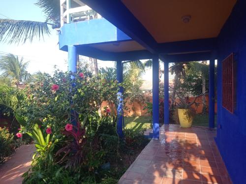 a blue house with a garden with flowers at Charming blue house with kitchen parking and garden in Canoa Quebrada