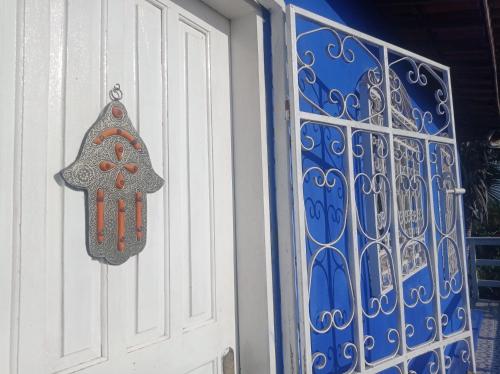 a door with a ornament on it next to a gate at Charming blue house with kitchen parking and garden in Canoa Quebrada