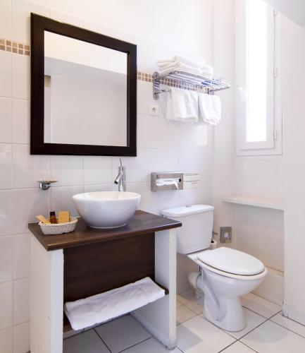 a bathroom with a sink and a toilet and a mirror at Hôtel La Villa Tosca in Cannes