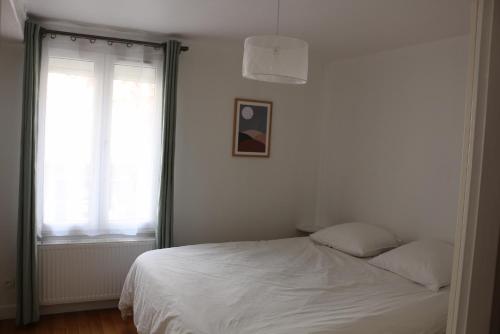 a white bed in a bedroom with a window at Moulins F3 hyper centre de Saint Dizier in Saint-Dizier