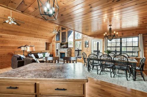 a kitchen and living room with a table and chairs at Kate's Cabin - 3 min to Dollywood! Cabin with Hot tub, Game Room, and Resort Pool! in Sevierville