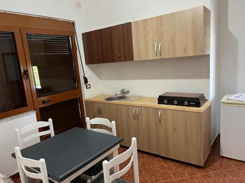 een kleine keuken met een tafel en een tafel en stoelen bij Apartament i kendshem in Kavajë