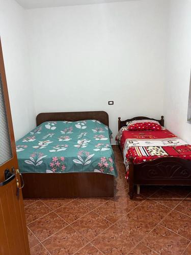 een slaapkamer met 2 aparte bedden in een kamer bij Apartament i kendshem in Kavajë