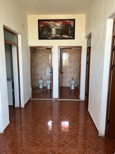 een grote badkamer met 2 toiletten en 2 wastafels bij Apartament i kendshem in Kavajë