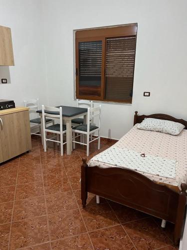 een slaapkamer met 2 bedden en een tafel en stoelen bij Apartament i kendshem in Kavajë